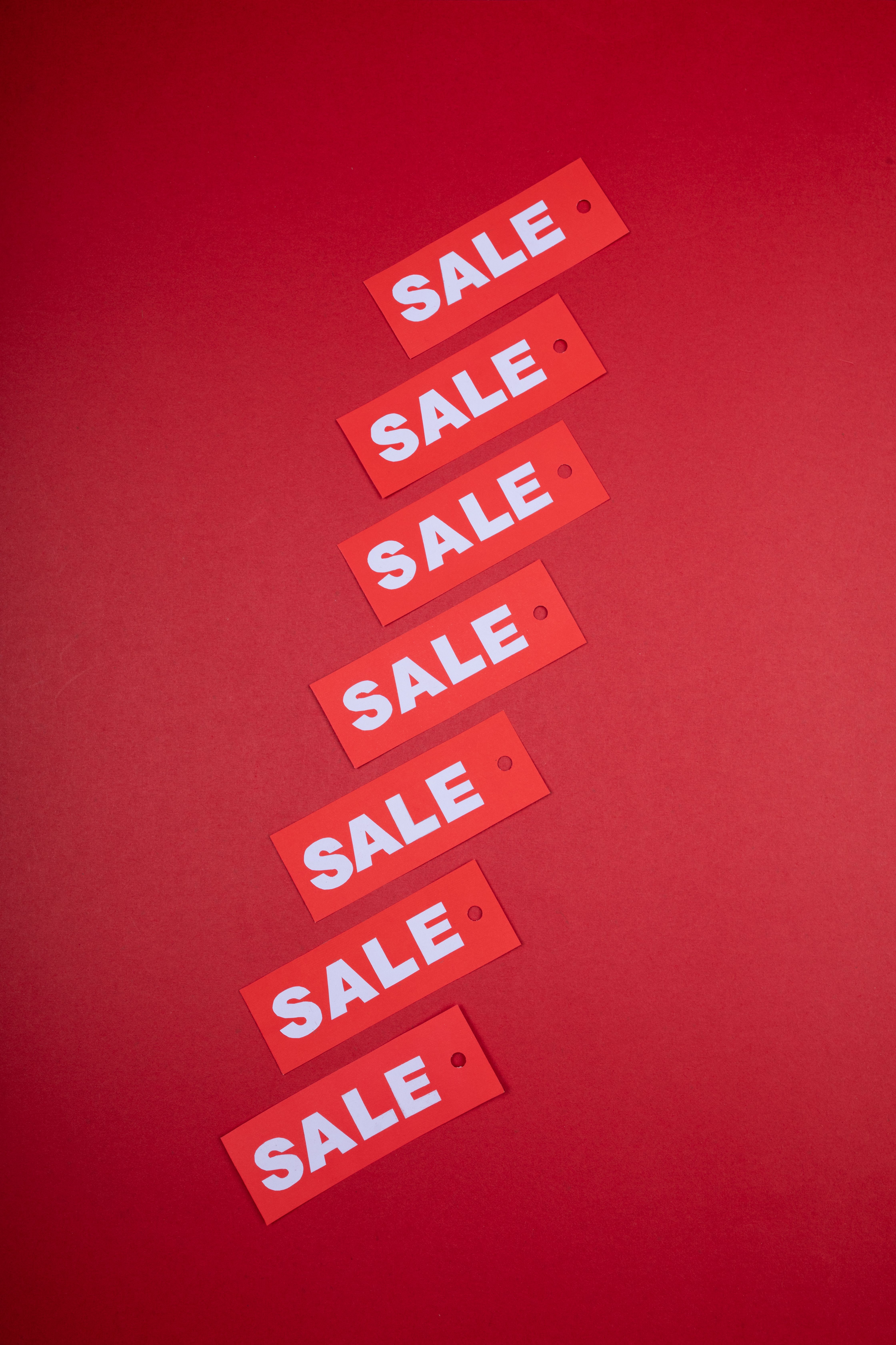 Red sale tags arranged vertically against a vivid red background
